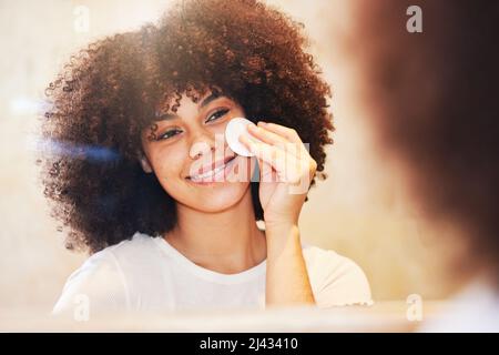 Prendre soin de votre peau est vraiment payant. Photo d'une belle jeune femme utilisant un tampon de coton pour nettoyer son visage. Banque D'Images