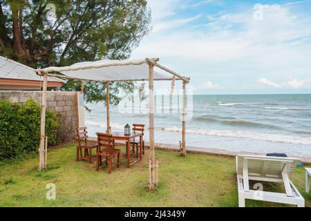 Belvédère en bois et chaise longue sur pelouse verte en mer tropicale et ciel bleu en été Banque D'Images