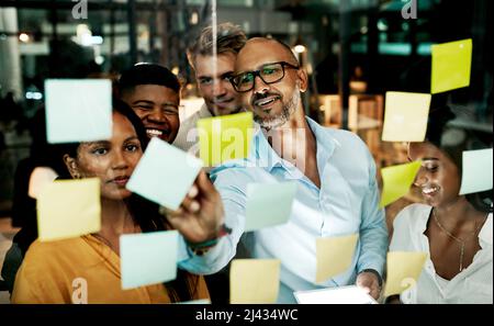 Transformer l'entreprise en machine marketing. Photo d'un groupe d'hommes d'affaires ayant une séance de remue-méninges tard dans la nuit dans un bureau moderne. Banque D'Images