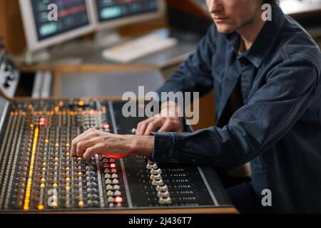 Prise de vue rognée d'un homme du producteur de musique utilisant une station de travail audio numérique dans un studio d'enregistrement professionnel, espace de copie Banque D'Images