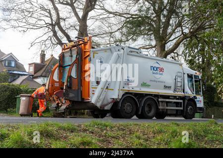 Norse camion-poubelle du Sud-est, fournissant des services d'élimination des déchets à East Hampshire, Angleterre, Royaume-Uni, avec un binman vidant les poubelles domestiques Banque D'Images