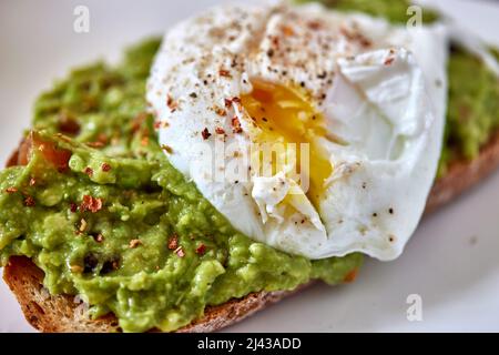 Toast à l'avocat avec œuf sur l'assiette - vue rapprochée Banque D'Images