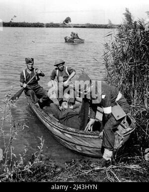 Cinquième Croix le Volturno: Une victime précoce est ramenée au Sud dans l'un des bateaux d'assaut. Pendant les heures de ténèbres, le 14/15 1943 octobre, la cinquième armée a lancé sa grande attaque sur le fleuve Volturno. Bientôt plusieurs têtes de pont étaient dans les mains alliées et l'Armour a commencé à faire le passage de la rivière. Maintenant (19.10.43) les forces alliées sont bien au-dessus de la rivière à plusieurs points et ont occupé la ville de Cancello, à environ 6 milles de la côte et de l'estuaire du Volturno, après un féroce cont Banque D'Images