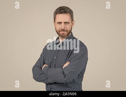 Homme barbu dans une chemise de style décontracté garder les bras croisés sentiment de confiance fond gris, confortable Banque D'Images