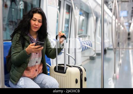 Femme passager utilisant le téléphone dans une voiture de métro Banque D'Images