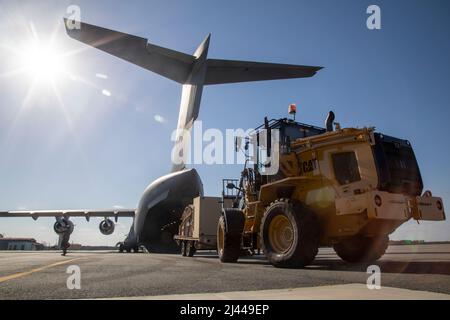 Des soldats affectés à Echo Company, 3rd Aviation Regiment, 3rd combat Aviation Brigade, 3rd Infantry Division, chargent un système de communications par satellite sur un C-17 Globemaster III à l'aéroport régional de Midcoast, fort Stewart (Géorgie), le 8 avril 2022. Les soldats se sont déployés à fort Huachuca, en Arizona, pour appuyer les efforts de sécurité et de reconnaissance des douanes et de la protection des frontières des États-Unis, en utilisant le nouvel Eagle gris à portée étendue MQ-1C-25. (É.-U. Photo de l'armée par le Sgt. Savannah Roy, 3rd Brigade de l'aviation de combat, 3rd Division d'infanterie) Banque D'Images