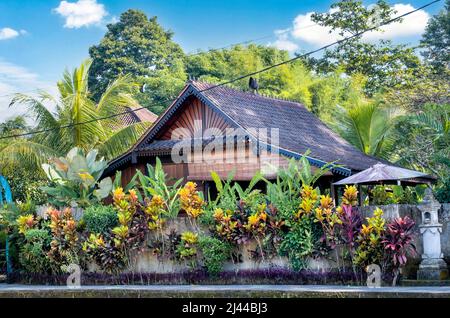 Belle vue sur Bali villa, architecture balinaise traditionnelle et paysage de plantes tropicales avec ciel bleu et nuages dispersés fond en Indonésie Banque D'Images