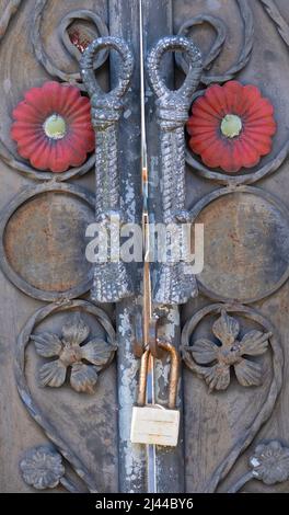 Ancienne serrure en laiton d'époque à poignées de porte forgées en fer sur porte balinaise en bois sculpté en Indonésie Banque D'Images