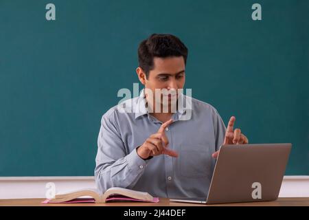 Enseignant d'école menant une classe en ligne à l'aide d'un ordinateur portable Banque D'Images