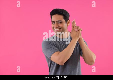 Portrait d'un jeune homme heureux faisant le geste de prise de vue par ses mains Banque D'Images