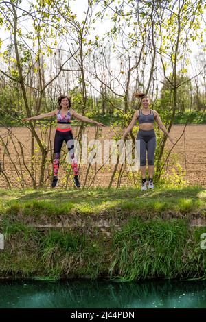 les femmes qui s'exécutent le long des rives d'une crique portent des vêtements de sport - concept de mode de vie sain Banque D'Images