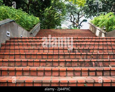 Escalier pavé en brique rouge avec mains courantes dans un parc Banque D'Images