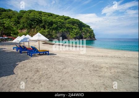 Parasols et chaises longues sur Virgin Beach, une plage de sable blanc à Karangsarem, à l'est de Bali, en Indonésie. Banque D'Images