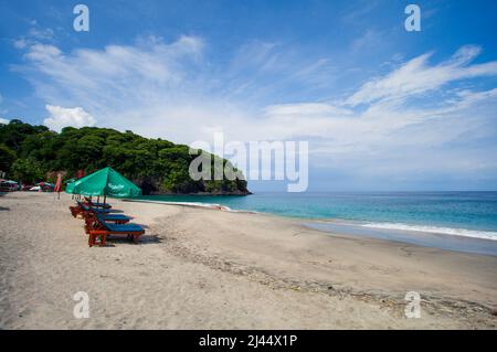 Parasols et chaises longues sur Virgin Beach, une plage de sable blanc à Karangsarem, à l'est de Bali, en Indonésie. Banque D'Images