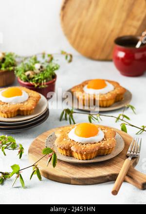 Gâteaux frais en forme de fleur sucrée avec abricot, glaçage et noix d'amande hachées. Banque D'Images