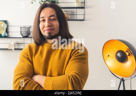 Jeune homme caucasien croisant ses bras, regardant la caméra, confiant regarder à la maison arrière-plan copie espace . Photo de haute qualité Banque D'Images