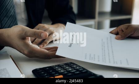 Une femme prend la poignée à l'enveloppe de démission tout en étant remise à la femme gestionnaire. Banque D'Images