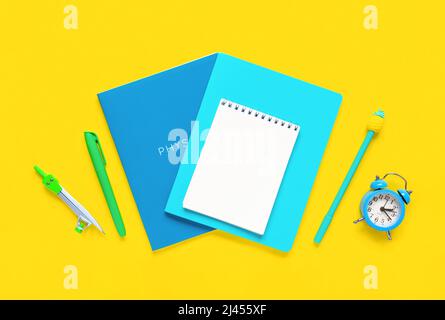 Fournitures scolaires sur fond jaune. Différents articles de papeterie avec espace vide sur un bureau. Vue du dessus, plan d'appartement. Photo avec copybook. Rentrée des classes Banque D'Images