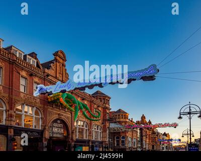 Des enseignes lumineuses au néon sont suspendues à Briggate, au crépuscule. Leeds, Royaume-Uni Banque D'Images