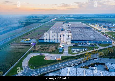 Une photo d'un coucher de soleil sur un immense espace de stockage situé dans la banlieue de Gilwice, en Pologne. Banque D'Images