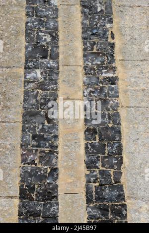 Deux colonnes de pièces de flanelle ornementales, coupées et fixées dans la pierre d'un mur d'église. Banque D'Images