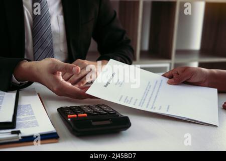 Une femme prend la poignée à l'enveloppe de démission tout en étant remise à la femme gestionnaire. Banque D'Images