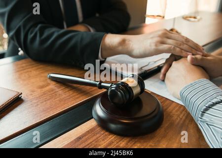 L'avocat et le tribunal utilisent leurs mains pour console le client qui sait qu'il ne gagnera pas l'affaire. Banque D'Images