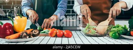 Deux jeunes couples asiatiques s'aident les uns les autres et apprécient la cuisine. Banque D'Images