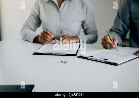 Le mari et la femme ont créé des caisses pour signer les documents de divorce au bureau de l'avocat. Banque D'Images