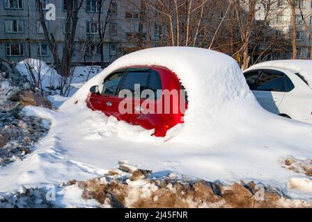 Voiture de tourisme rouge sous un déneigement Banque D'Images