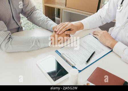 Le médecin a serré les mains et consolé les patients qui s'inquiétaient du traitement. Banque D'Images