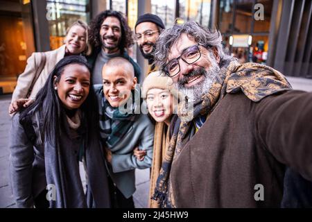 Des collègues heureux prenant un selfie ensemble à l'extérieur. Banque D'Images