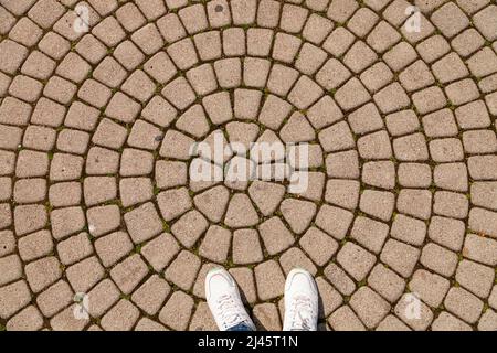 Femme pieds sur la vieille route de pierre Banque D'Images