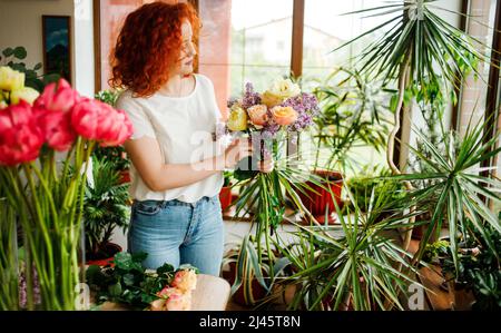 Portrait d'une charmante fille aux cheveux rouges avec un bouquet entre ses mains Banque D'Images