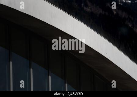 Détail architectural de poutre de toit en béton blanc voûté inclinée au-dessus de la façade en verre et en aluminium Banque D'Images