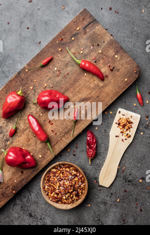 Variété de piments frais et séchés sur fond rustique Banque D'Images