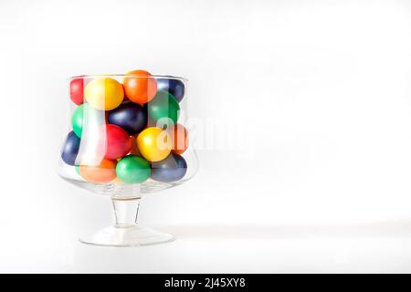 Œufs peints multicolores dans un vase en verre. Concept de Pâques. Un endroit prêt pour votre texte d'invitation, Félicitations. Banque D'Images