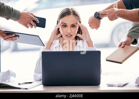 Pouvez-vous me laisser faire une chose. Photo d'une jeune femme d'affaires attirante assise au bureau et se sentant stressée pendant que ses collègues mettent de la pression Banque D'Images