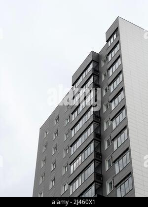Vue à angle bas depuis le dessous du nouveau bâtiment gris d'appartements à plusieurs étages qui a été déplacé par beaucoup de personnes grâce à un programme de rénovation Banque D'Images