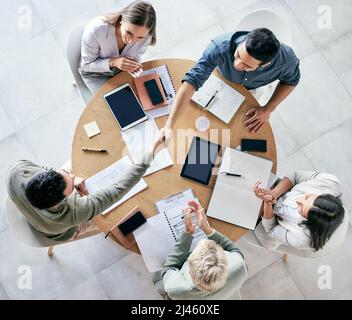 Nous nous efforçons de devenir meilleurs que nous. Coup de main d'hommes d'affaires en train de se serrer la main lors d'une réunion d'équipe dans un bureau moderne. Banque D'Images