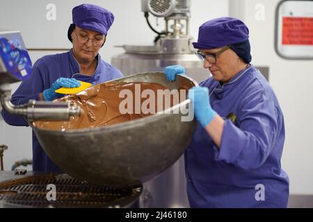 Dawn Jenks et Donna Oluban, chocolatiers de Cadbury World, créent un gros œuf de chocolat lorsqu'ils travaillent sur leur création de chocolat sur le thème de Pâques à Cadbury World à Birmingham. Date de la photo: Mardi 12 avril 2022. Banque D'Images