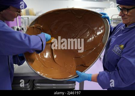 Dawn Jenks et Donna Oluban, chocolatiers de Cadbury World, créent un gros œuf de chocolat lorsqu'ils travaillent sur leur création de chocolat sur le thème de Pâques à Cadbury World à Birmingham. Date de la photo: Mardi 12 avril 2022. Banque D'Images