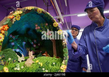 Dawn Jenks et Donna Oluban, chocolatiers du monde de Cadbury, ajoutent la touche finale à leur création de chocolat sur le thème de Pâques à Cadbury World à Birmingham. Date de la photo: Mardi 12 avril 2022. Banque D'Images