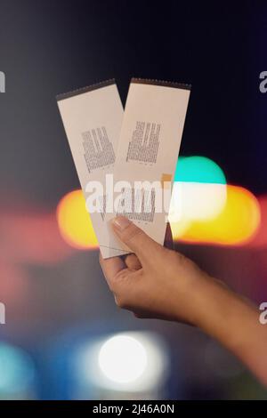 Date la nuit commence ici. Prise de vue d'une personne méconnaissable tenant deux billets. Banque D'Images