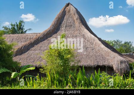 Cabane indonésienne avec toit de chaume, en pailles et bâtonnets de bambou. Fond bleu ciel et nuages Banque D'Images