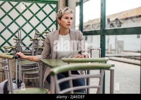 Je pense triste de voyager femme attendant dans un café à la gare Banque D'Images