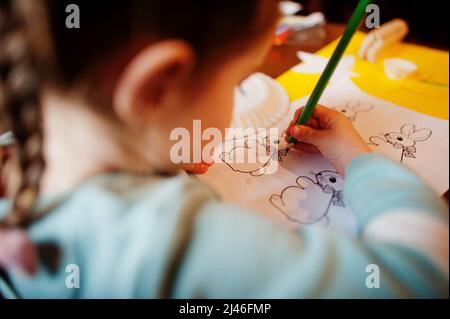 Préparation au concept de Pâques. Petite fille dessin lapin. Banque D'Images