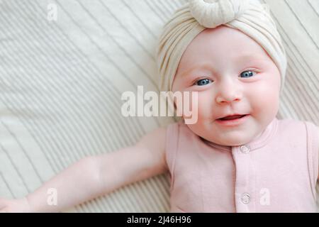 bébé fille à yeux bleus caucasiens, allongé sur le dos Banque D'Images