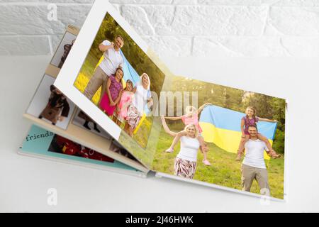 Archives photos de famille enregistrées dans un livre photo aux couleurs vives ; souvenirs d'été éclatants placés dans le livre photo. Famille avec drapeau de l'ukraine Banque D'Images