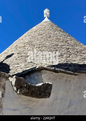 Le toit conique, au sommet, d'une maison traditionnelle de roche trullo vieille de 500 ans à Alberobello, en Italie. Banque D'Images